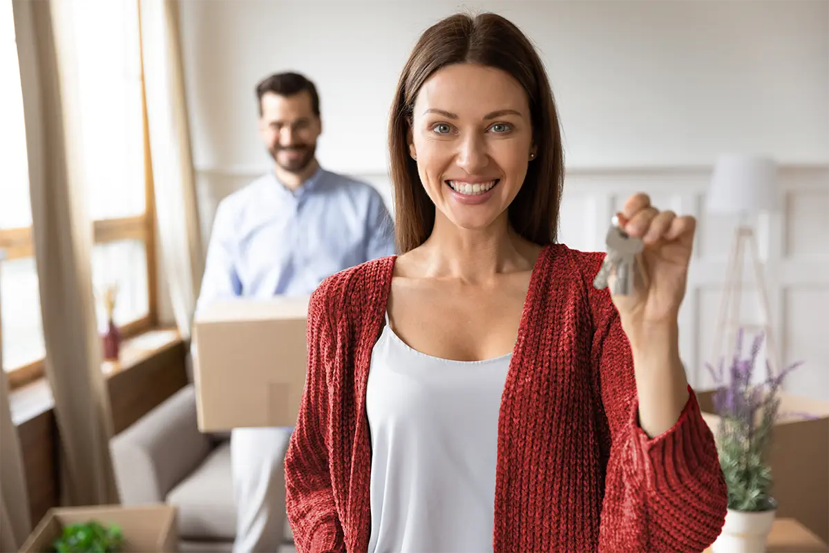 woman holding keys and man holding box