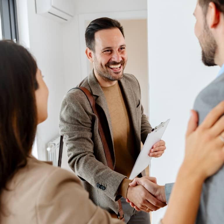 man shaking hands with couple