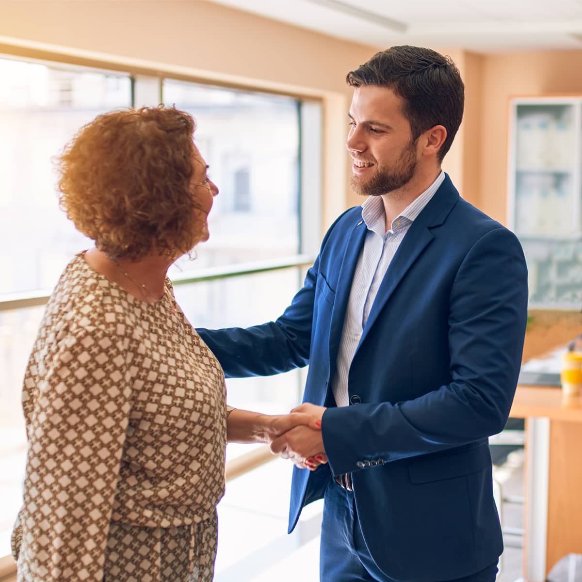man shaking hand of older woman
