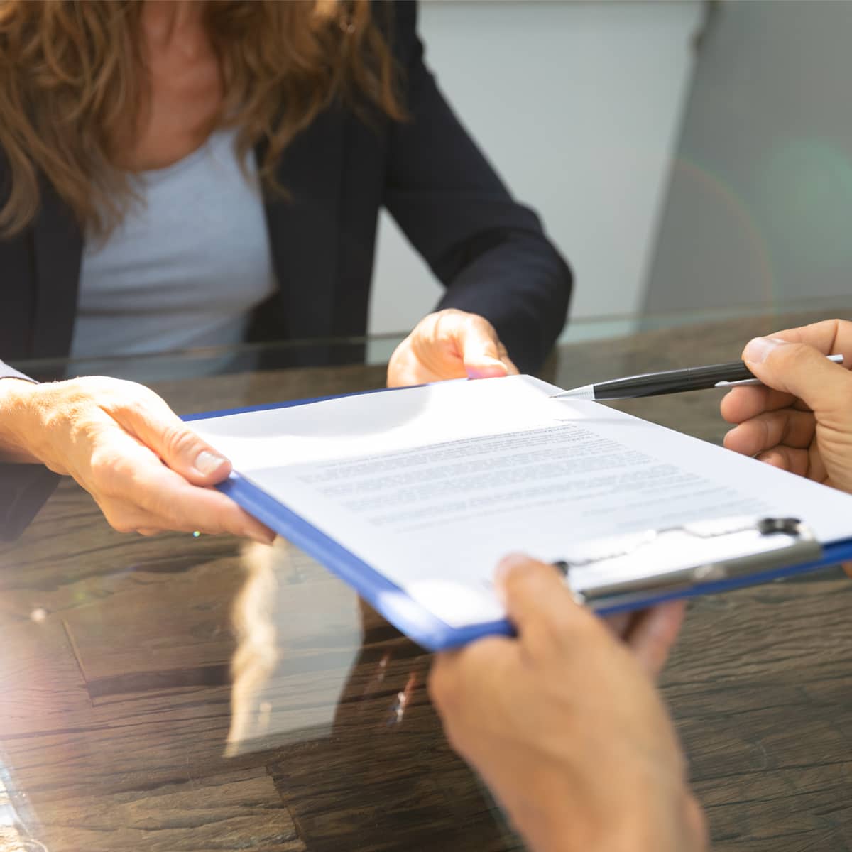 woman reading paperwork on a clipboard
